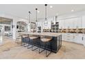 Open concept kitchen with large island and breakfast bar, white cabinetry, and a view to living area at 8575 E Sharon Dr, Scottsdale, AZ 85260