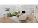 Living room with green sofa, wood floors, and a TV at 2320 W Forest Pleasant Pl, Phoenix, AZ 85085