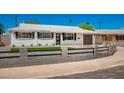 Newly remodeled mid-century modern home with a gray fence and landscaping at 7508 E Beatrice St, Scottsdale, AZ 85257