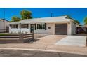 Newly remodeled mid-century modern home with a gray fence and landscaping at 7508 E Beatrice St, Scottsdale, AZ 85257