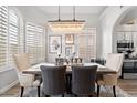 Bright dining room with a large chandelier and rustic wooden table at 9056 E Maple Dr, Scottsdale, AZ 85255