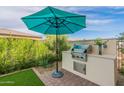 Built-in outdoor kitchen with grill and seating area at 726 E Citrus Hollow Way, Queen Creek, AZ 85140