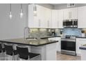 Modern kitchen with white cabinets, breakfast bar, and stainless steel appliances at 7700 E Gainey Ranch Rd # 206, Scottsdale, AZ 85258
