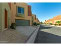 Tan stucco building with green garage doors and landscaping at 7601 E Roosevelt St # 1010, Scottsdale, AZ 85257