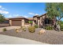 Beautiful home exterior with a two-car garage and desert landscaping at 26322 W Firehawk Dr, Buckeye, AZ 85396