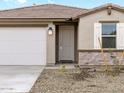 Front view of a new home with a stone accent at 16033 W Hackamore Dr, Surprise, AZ 85387