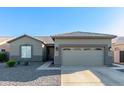 Single-story home with attached garage and desert landscaping at 13585 W Ironwood St, Surprise, AZ 85374