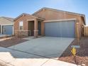 Front view of a single-story house with a gray garage door at 17431 W Sanna St, Waddell, AZ 85355