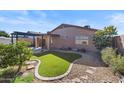 Landscaped backyard with artificial turf, a pergola, and a patio area at 9610 W Carol Ave, Peoria, AZ 85345