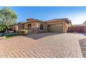 Home exterior with paver driveway and three-car garage at 2299 E Saddlebrook Rd, Gilbert, AZ 85298