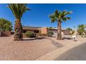 Single story home with a two-car garage and mature palm trees at 26632 S Snead Dr, Sun Lakes, AZ 85248