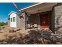 Inviting front porch with red door and seating area at 8052 E Mcdowell Rd, Mesa, AZ 85207