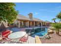 Inviting backyard oasis featuring a sparkling pool and patio seating at 13348 W Cambridge Ave, Goodyear, AZ 85395