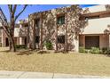 Building exterior with landscaping and a tree in front at 1920 W Lindner Ave # 137, Mesa, AZ 85202