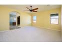 Bright bedroom with carpeted floor, ceiling fan, and ensuite bathroom access at 29408 N 244Th Dr, Wittmann, AZ 85361