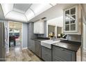Modern kitchen with gray cabinets, a farmhouse sink, and stainless steel appliances at 11405 S Tawa Ln, Phoenix, AZ 85044