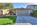 Ranch-style house with a green lawn and a two-car garage at 44977 W Miraflores St, Maricopa, AZ 85139