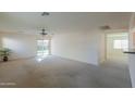 Spacious living room with carpet, sliding doors and ceiling fan at 44977 W Miraflores St, Maricopa, AZ 85139