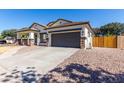 One-story home with gray garage door and wood fence at 3759 S Dew Drop Ln, Gilbert, AZ 85297