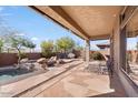 Covered patio with a built-in fire pit and a swimming pool at 2339 W Hazelhurst Dr, Anthem, AZ 85086