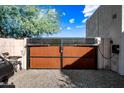 Automated, modern, brown corrugated metal gate at 6520 N 130Th Ln, Glendale, AZ 85307