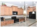 Kitchen boasts ample cabinetry, granite countertops, and black appliances at 901 W Witt Ave, Queen Creek, AZ 85140
