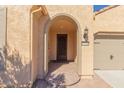 Inviting front entry with arched entryway and stone detailing at 27036 W Sequoia Dr, Buckeye, AZ 85396