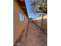 Long, narrow side yard with dirt ground and wooden fence at 3542 E Earll Dr, Phoenix, AZ 85018