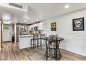 Modern kitchen with white cabinets, island, and wood floors at 27250 N 64Th St # 1, Scottsdale, AZ 85266