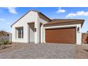 New construction home with a brown garage door and stone driveway at 610 E Aurora Dr, San Tan Valley, AZ 85140