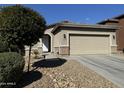 One-story home with tan exterior, two-car garage, and desert landscaping at 20216 W Desert Bloom St, Buckeye, AZ 85326