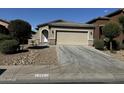 Front view of a one-story house with a two-car garage and landscaping at 20216 W Desert Bloom St, Buckeye, AZ 85326