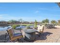 Relaxing patio with fire pit and seating area near a tranquil pond at 16866 S 180Th Ave, Goodyear, AZ 85338