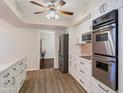 Bright kitchen features white cabinets, stainless steel appliances, and quartz countertops at 13403 N Cedar Dr, Sun City, AZ 85351