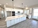 Spacious kitchen with white cabinets, large island, and stainless steel appliances at 1716 W Lucky Ln, Queen Creek, AZ 85144