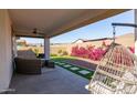 Relaxing backyard patio with seating area, putting green, and bougainvillea at 19922 W Exeter Blvd, Litchfield Park, AZ 85340