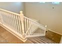 Elegant staircase with white railings and carpeted steps at 15685 W Mackenzie Dr, Goodyear, AZ 85395
