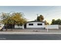 White single story house with a landscaped front yard and a white fence at 2207 E Aspen Ave, Mesa, AZ 85204