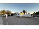 White single story house with gravel front yard, and a white fence at 2207 E Aspen Ave, Mesa, AZ 85204