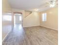 Bright living room with laminate floors and access to other rooms at 42564 W Palmyra Ln, Maricopa, AZ 85138