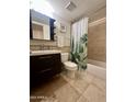 Clean bathroom with dark vanity, shower/tub combo, and decorative shower curtain at 1213 E Lawrence Ln, Phoenix, AZ 85020