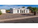 White single story home with a rock front yard and palm tree at 319 S 84Th Way, Mesa, AZ 85208