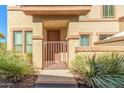 Townhome entrance with a brown door and metal gate at 42424 N Gavilan Peak Pkwy # 50104, Anthem, AZ 85086