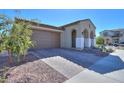 Front view of a house with a brown garage door and a landscaped yard at 9515 E Rainbow Ave, Mesa, AZ 85212