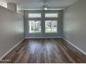 Spacious living room featuring large windows and wood-look floors at 13335 W Broken Arrow Dr, Sun City West, AZ 85375