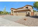 Three-car garage and front yard with drought-tolerant landscaping at 19435 N 62Nd Ave, Glendale, AZ 85308