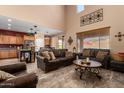 Spacious living room featuring high ceilings, dark leather furniture, and a large entertainment center at 6084 W Yorktown Way, Florence, AZ 85132