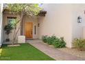 Inviting front entry with a wooden door and landscaped walkway at 14428 E Monument Dr, Scottsdale, AZ 85262