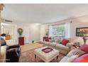 Bright and airy living room featuring a comfy sofa and ottoman at 10317 W Prairie Hills Cir, Sun City, AZ 85351