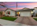 Charming house exterior with manicured lawn at sunset at 20428 W Elm Dr, Buckeye, AZ 85396
